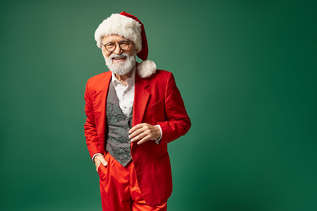 guapo elegante Santa con sombrero rojo navideño y gafas mirando a la cámara, concepto de invierno - Foto, Imagen