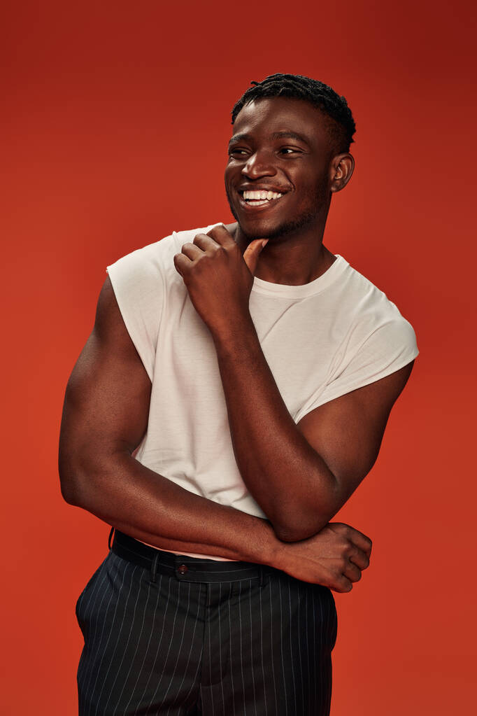 animado afro-americano homem em elegante rua desgaste olhando para longe e rindo em vermelho, vibrações positivas - Foto, Imagem