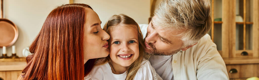ευτυχείς γονείς φιλιά χαρούμενη κόρη κοιτάζοντας κάμερα στην κουζίνα στο άνετο σπίτι, οριζόντια banner - Φωτογραφία, εικόνα