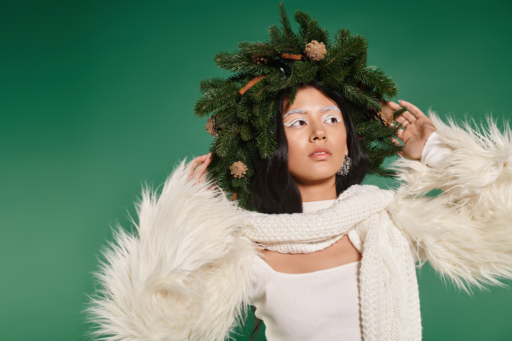Urlaubsstimmung, brünette Asiatin mit weißem Make-up und trendigem Outfit posiert im Kranz auf Grün - Foto, Bild