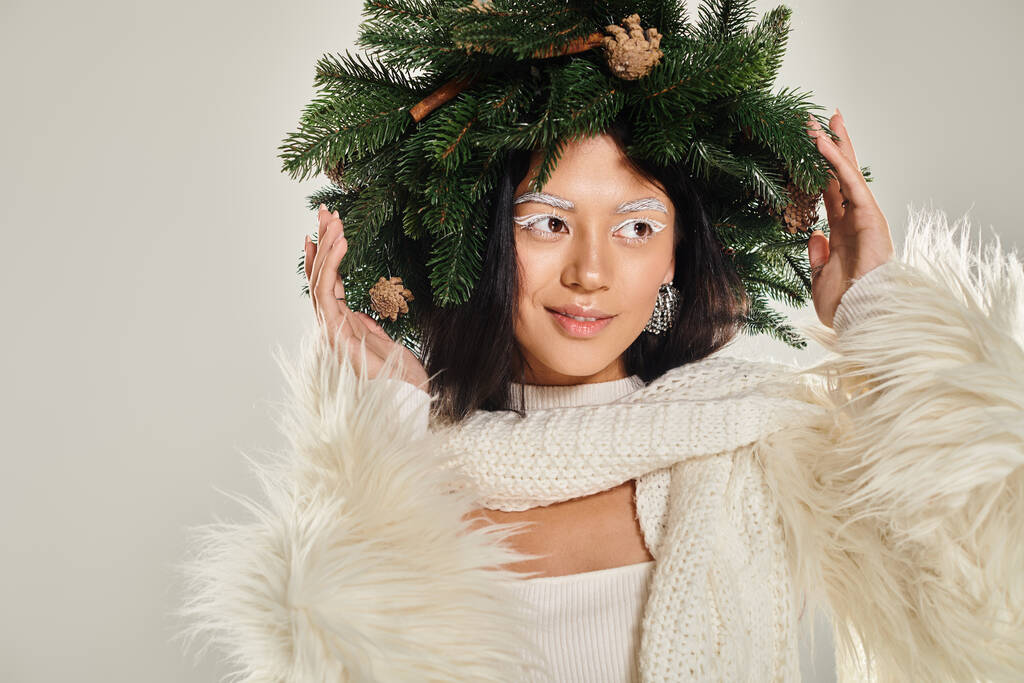 冬の美しさ,緑の背景に白い服でポーズする自然な松の羽を持つ肯定的な女性 - 写真・画像