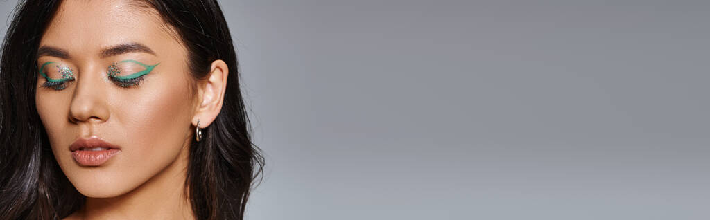 retrato de hermosa mujer asiática con cabello moreno, maquillaje de ojos brillantes y ojos cerrados, pancarta - Foto, imagen
