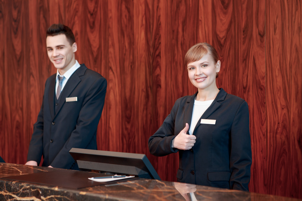 Hotel receptionisten achter de toonbank - Foto, afbeelding