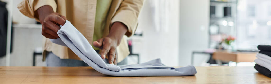 обрізаний вид афроамериканського працівника текстильної друкарні студії розкладний одяг акуратно, банер - Фото, зображення