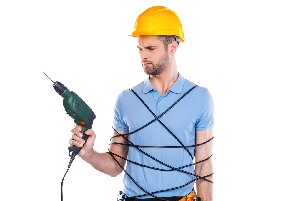Carpenter trapped in wire holding drill - Photo, Image