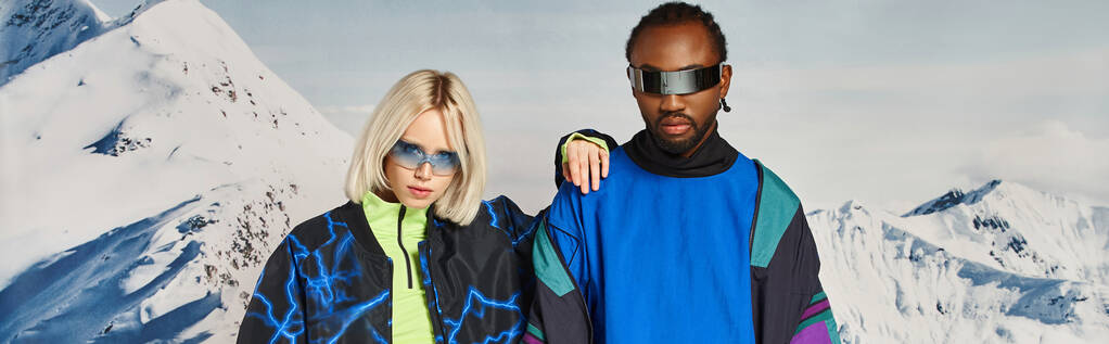 стильна пара в яскравому вбранні з сонцезахисними окулярами позує на сніжному тлі, зимовий концепт-банер - Фото, зображення