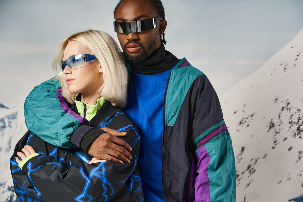 Stilvolles Paar posiert in warmer Kleidung mit leuchtenden Gläsern vor Bergkulisse, Winterkonzept - Foto, Bild