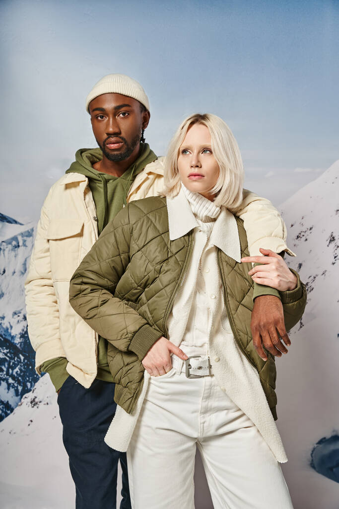 приваблива стильна пара в сезонних вбраннях позує разом з гірським тлом, зимова концепція - Фото, зображення