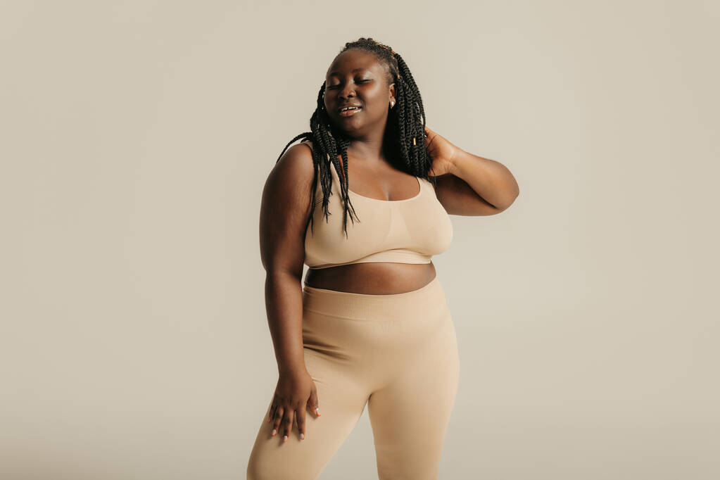 Attractive African curvy woman in underwear radiating self-love on studio background - Photo, Image