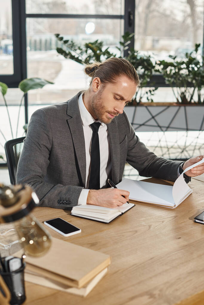 homem de negócios concentrado em desgaste formal trabalhando com notebooks perto de smartphone com tela em branco - Foto, Imagem