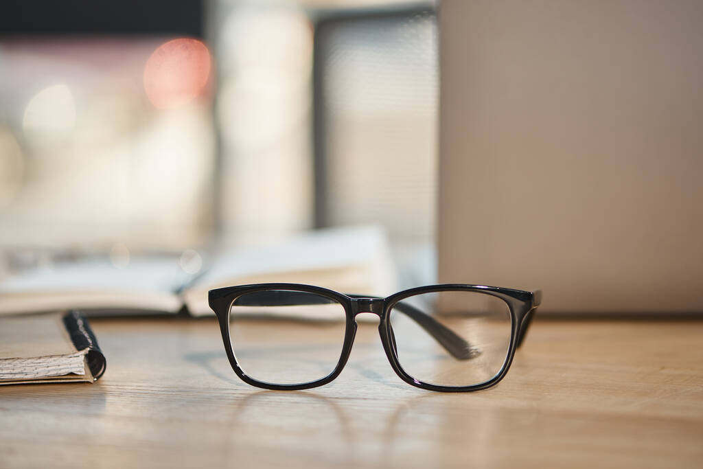 Çalışma masasındaki gözlüklerin modası bulanık arka plan, iş modası. - Fotoğraf, Görsel