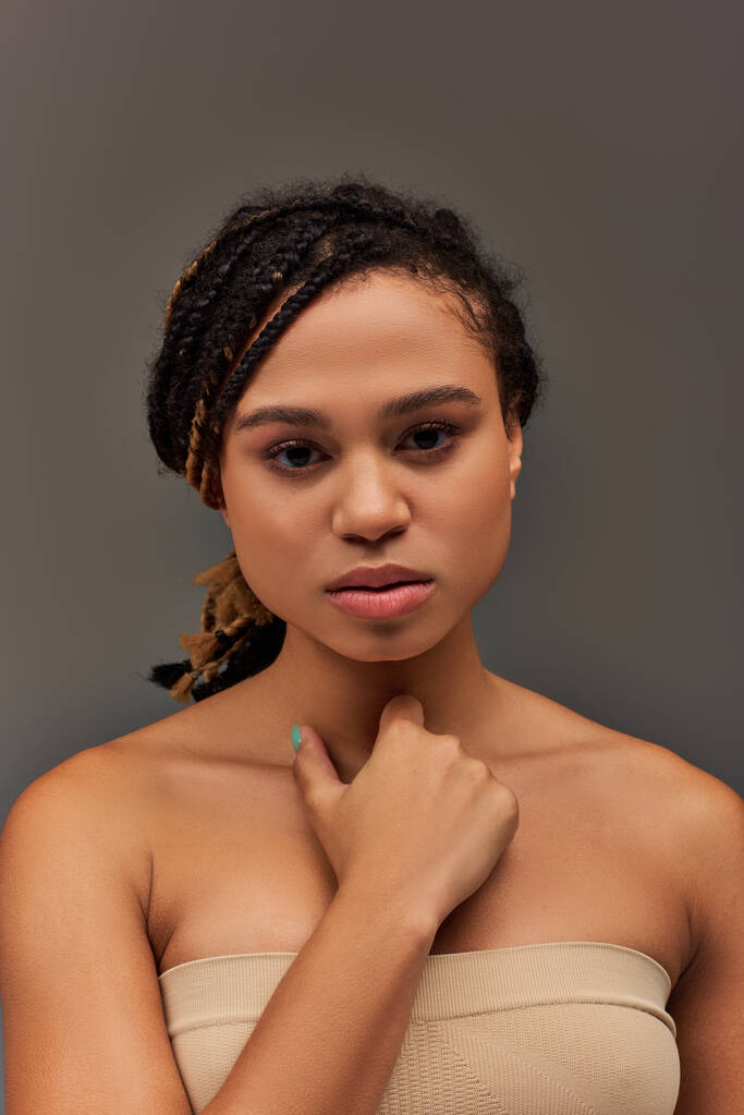 giovane donna afroamericana attraente in biancheria intima beige pastello posa sul serio, concetto di moda - Foto, immagini
