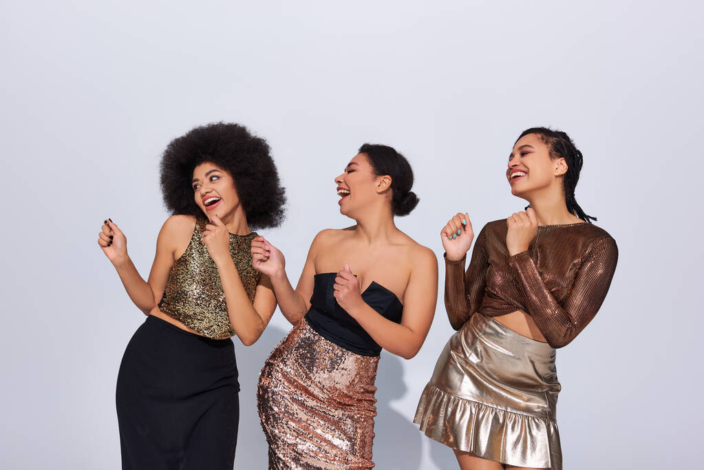 mujeres afroamericanas alegres en trajes festivos con lentejuelas fiesta juntos, concepto de moda - Foto, Imagen