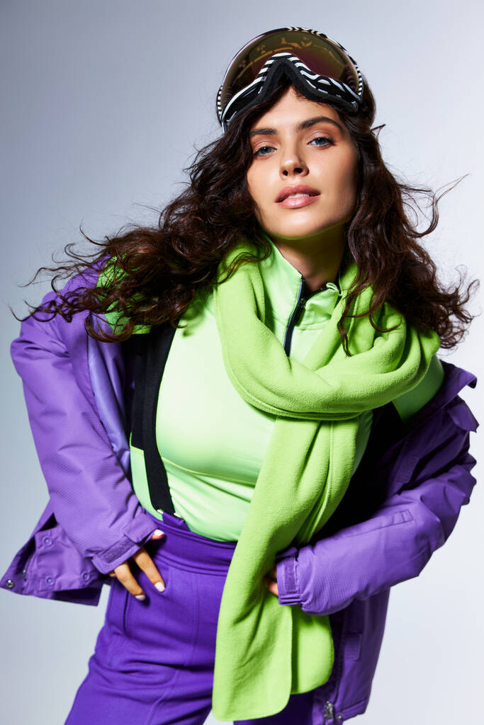 zima moda, piękna kobieta z brunetka włosy pozowanie w aktywny nosić z kurtka puffer na szary - Zdjęcie, obraz