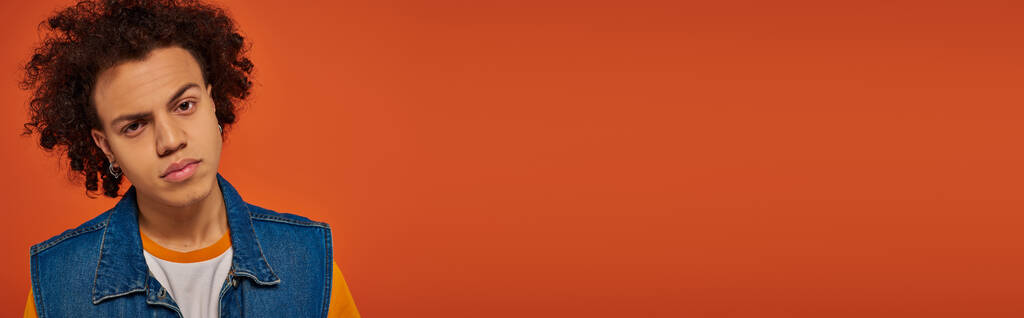 όμορφος Αφροαμερικάνος με casual urban ενδυμασία ποζάρει ενεργά σε πορτοκαλί φόντο, banner - Φωτογραφία, εικόνα