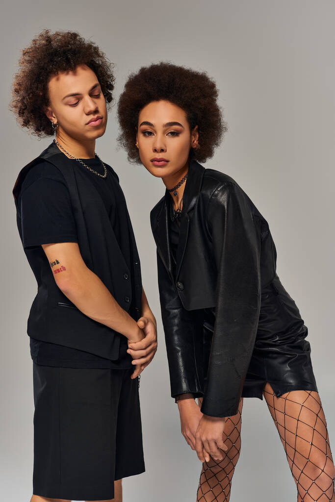 fashionable african american siblings in stylish black urban attire posing together on gray backdrop - Photo, Image