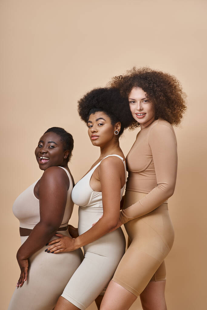 rozmanité multietnické plus velikost ženy ve spodním prádle s úsměvem na béžové, tělo pozitivní a přírodní krásy - Fotografie, Obrázek