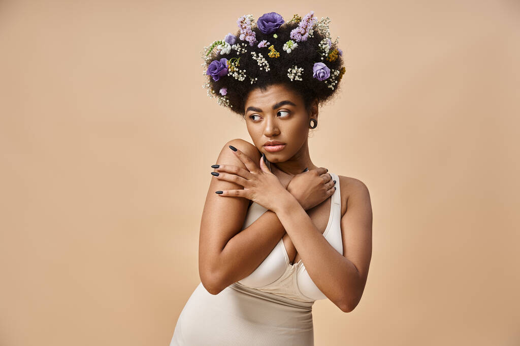 ベージュを見下ろす髪のカラフルな花を持つ魅力的なアフリカ系アメリカ人女性の肖像画 - 写真・画像