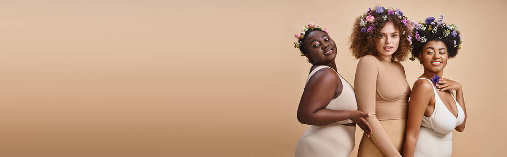 multietnické plus velikost ženy ve spodním prádle s barevnými květy ve vlasech na béžové, křivky šarm, banner - Fotografie, Obrázek