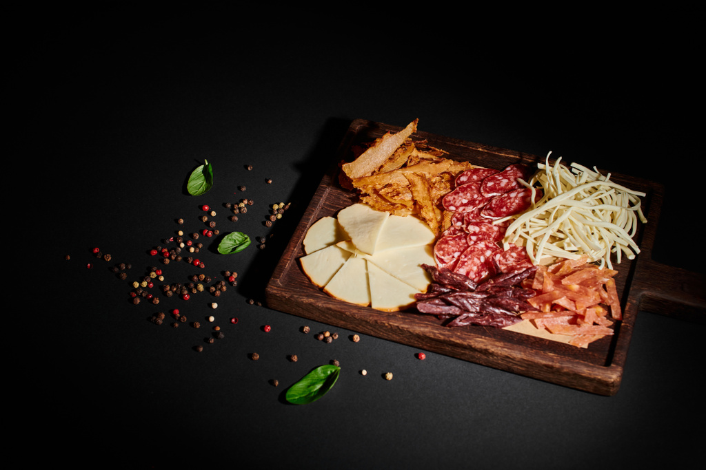vista de alto ângulo da placa de charcutaria com seleção de queijo gourmet, carne seca e fatias de salame - Foto, Imagem