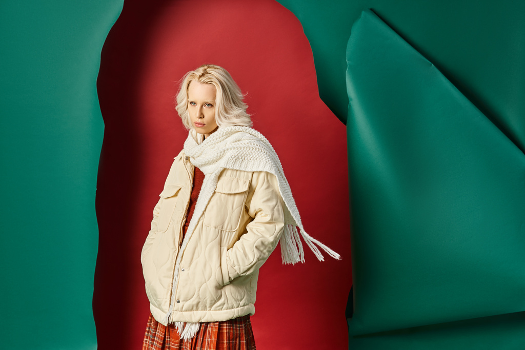 mulher elegante em casaco de inverno, cachecol e saia xadrez olhando para longe em vermelho com fundo turquesa - Foto, Imagem