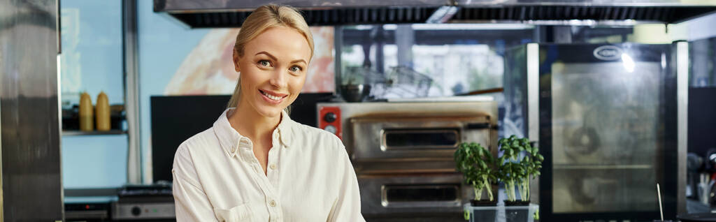 alegre rubia mujer de negocios sonriendo a la cámara en la cafetería moderna, pequeña empresa, pancarta horizontal - Foto, imagen