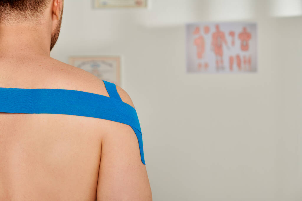 abgeschnittene Ansicht eines bärtigen Mannes mit kinesiologischen Bändern auf dem Rücken und den Schultern, Gesundheitswesen - Foto, Bild