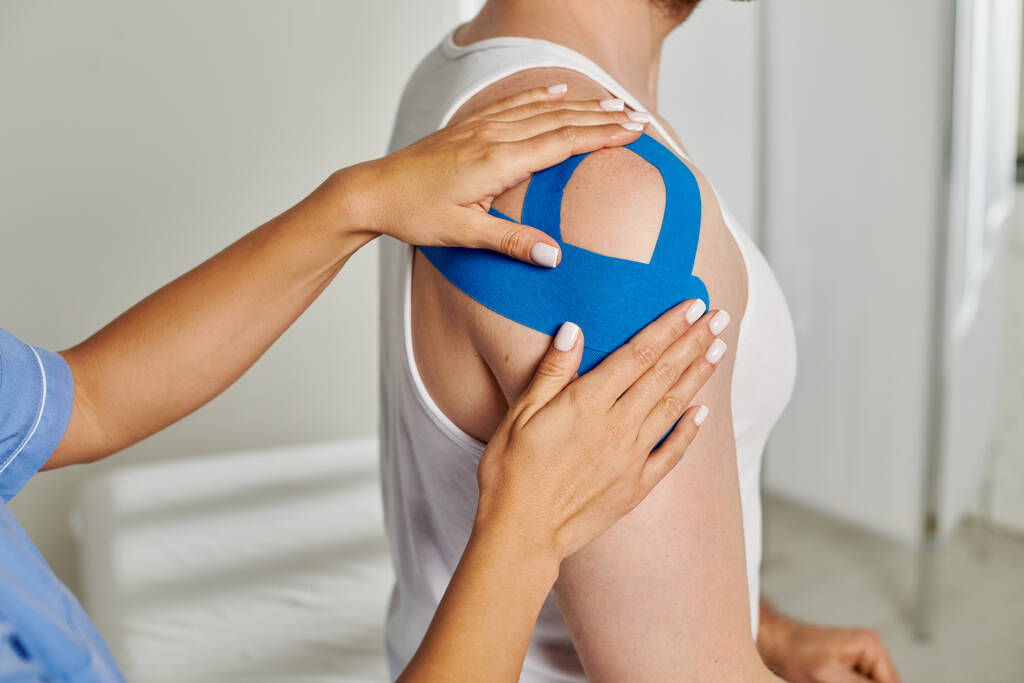 cropped view of patient on appointment while his doctor putting kinesio tapes on him, healthcare - Photo, Image