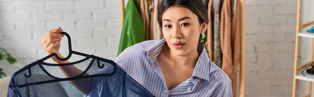 творческий молодой азиатский портниха с модной блузкой рядом с цифровой камерой в личном ателье, баннер - Фото, изображение