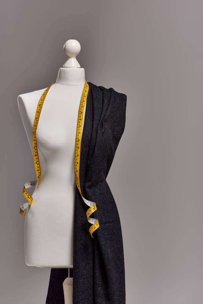 mannequin avec tissu de qualité et ruban à mesurer sur fond gris, concept d'entreprise de mode - Photo, image
