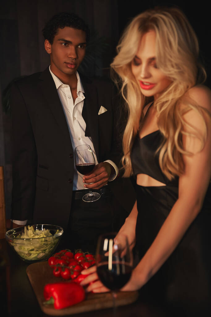 concentre-se no homem afro-americano bonito com um copo de vinho tinto olhando com carinho para sua namorada - Foto, Imagem