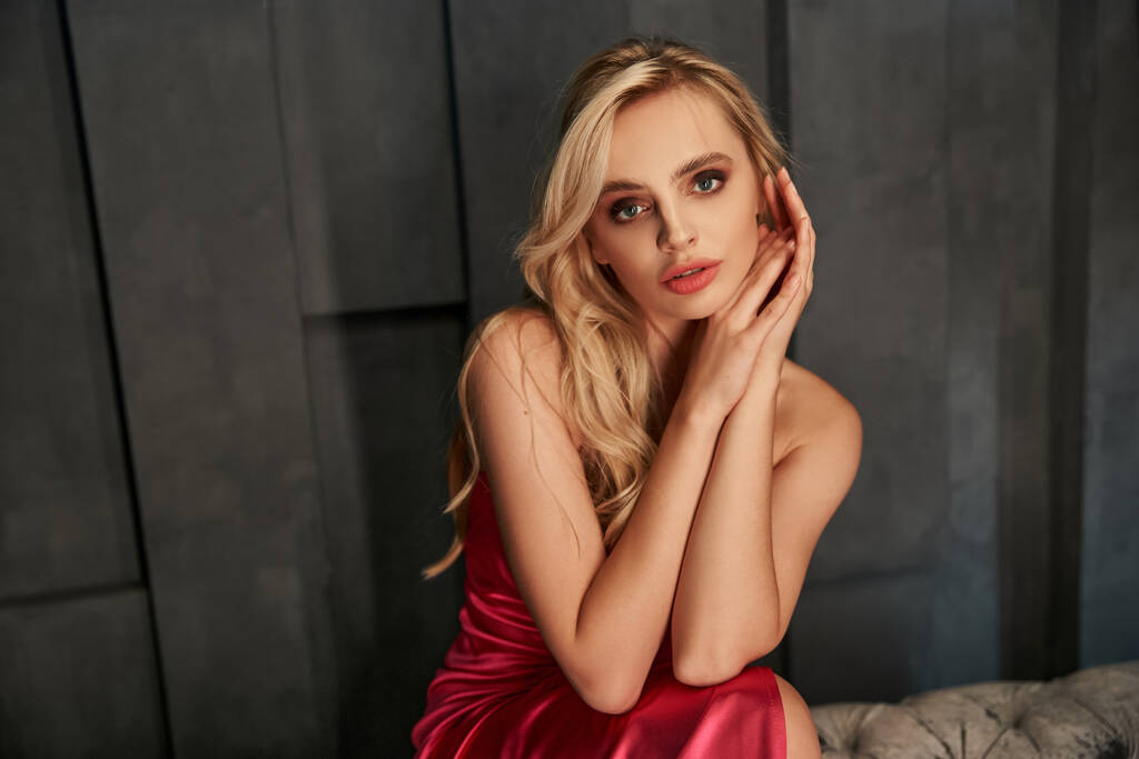 appealing sensual blonde woman in elegant evening dress posing and looking straight at camera - Photo, Image