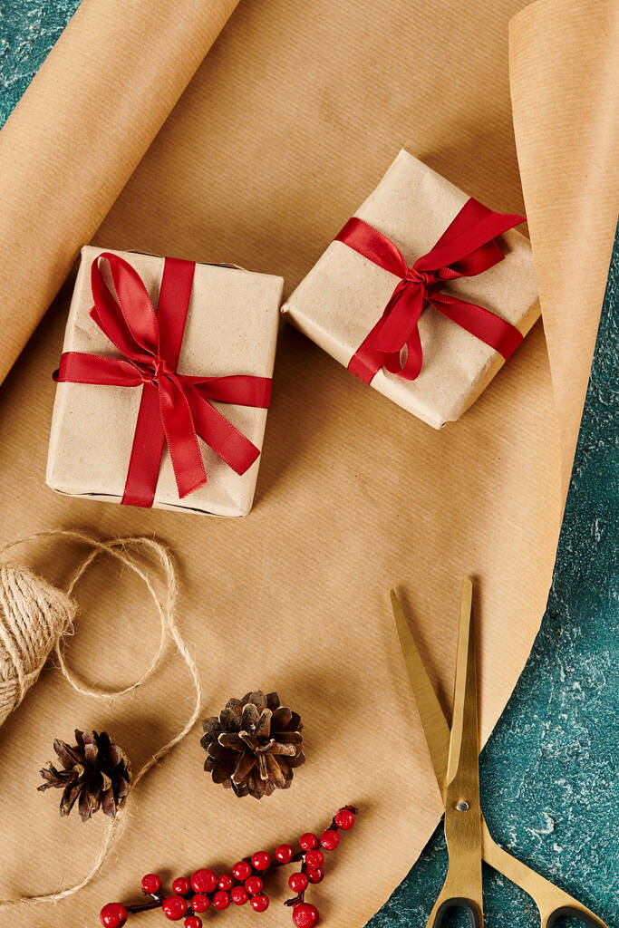 scatole regalo con nastri vicino alla carta artigianale e forniture di decorazioni festive sulla superficie blu, banner verticale - Foto, immagini