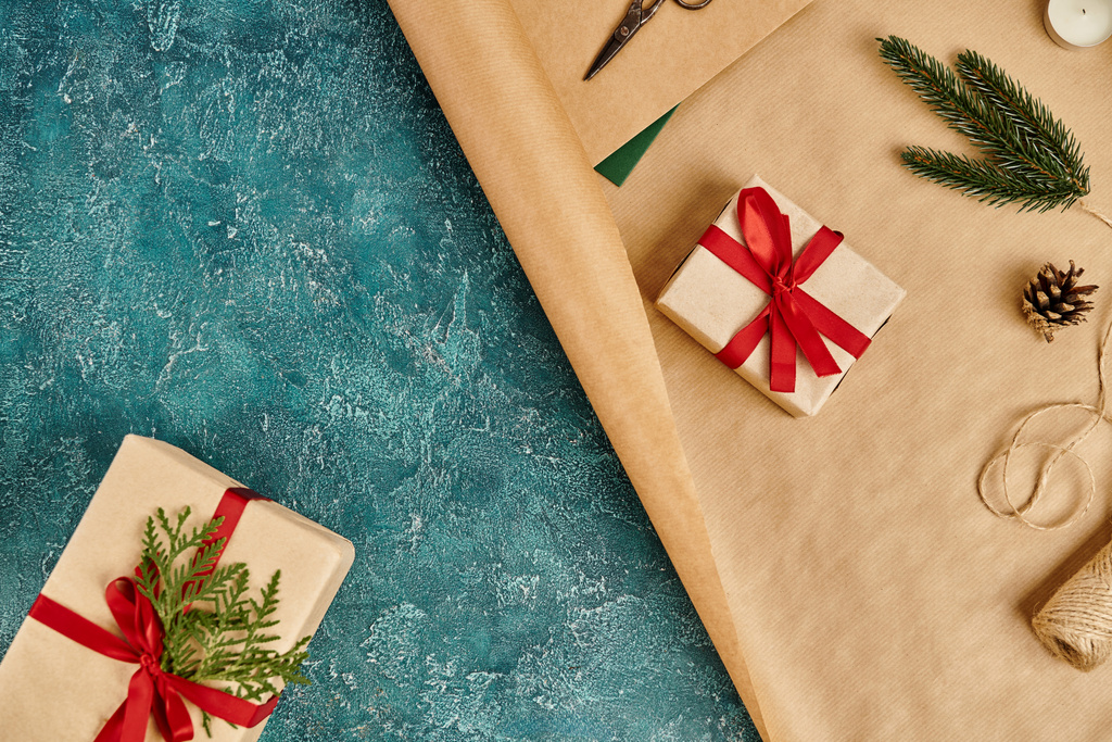 boîtes cadeaux et papier artisanal avec des fournitures de ficelle et de décoration sur surface texturée bleue, Noël - Photo, image