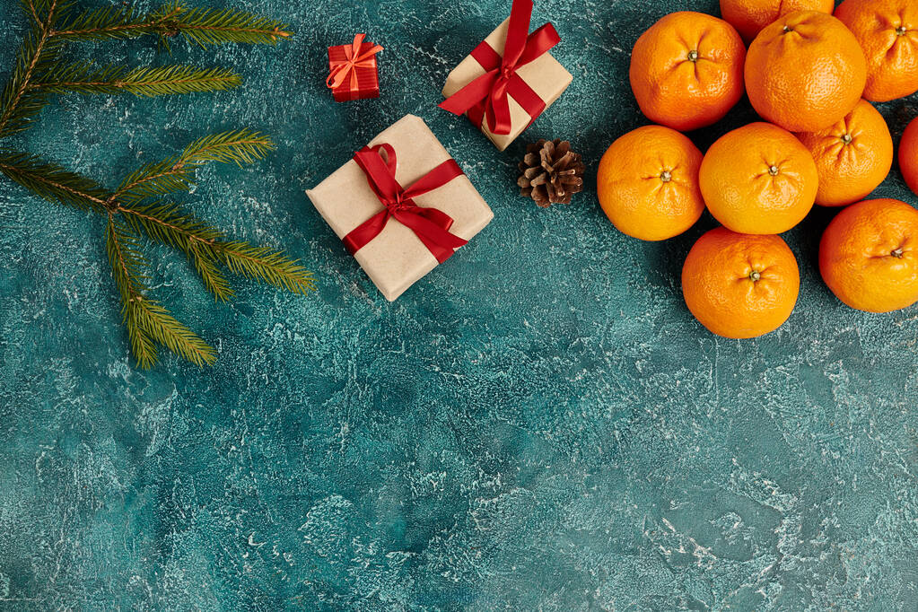 mandarinky a zdobené dárkové krabice v blízkosti borovice větve na modrém texturovaném pozadí, vánoční předměty - Fotografie, Obrázek