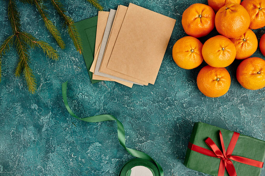 вітальні листи та мандарини біля гілок сосни та стрічки декору на синьому текстурованому фоні - Фото, зображення