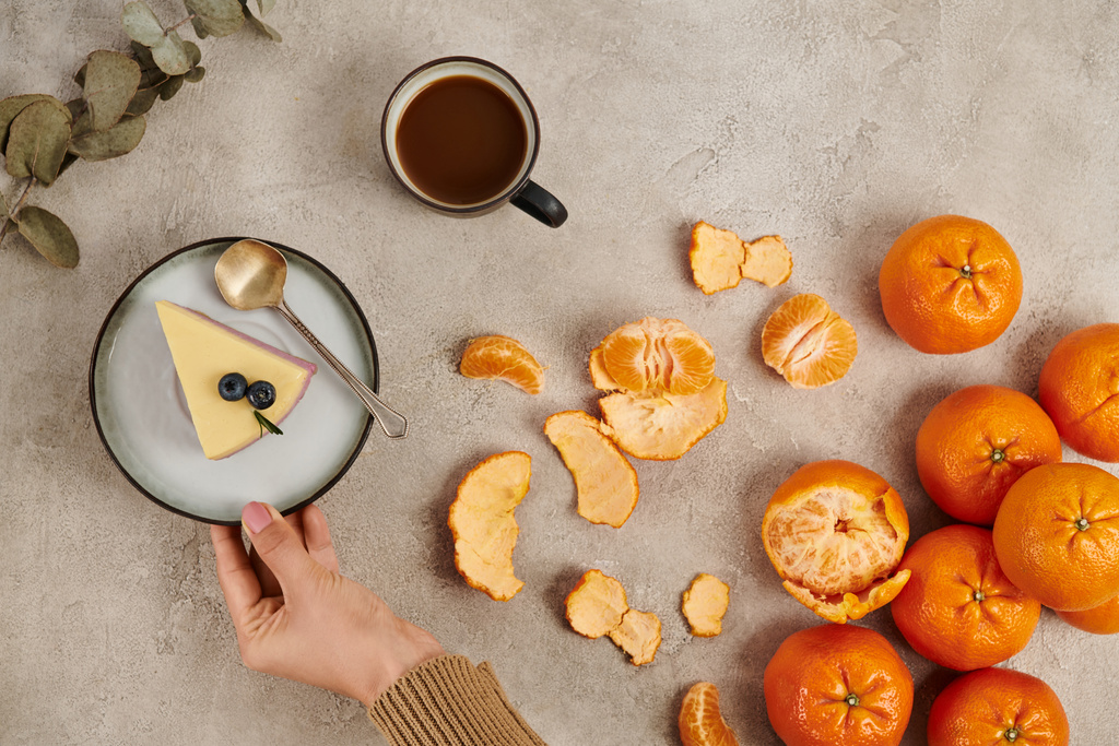cropped view of woman near pudding, tangerines and hot chocolate drink, traditional Christmas treats - Photo, Image
