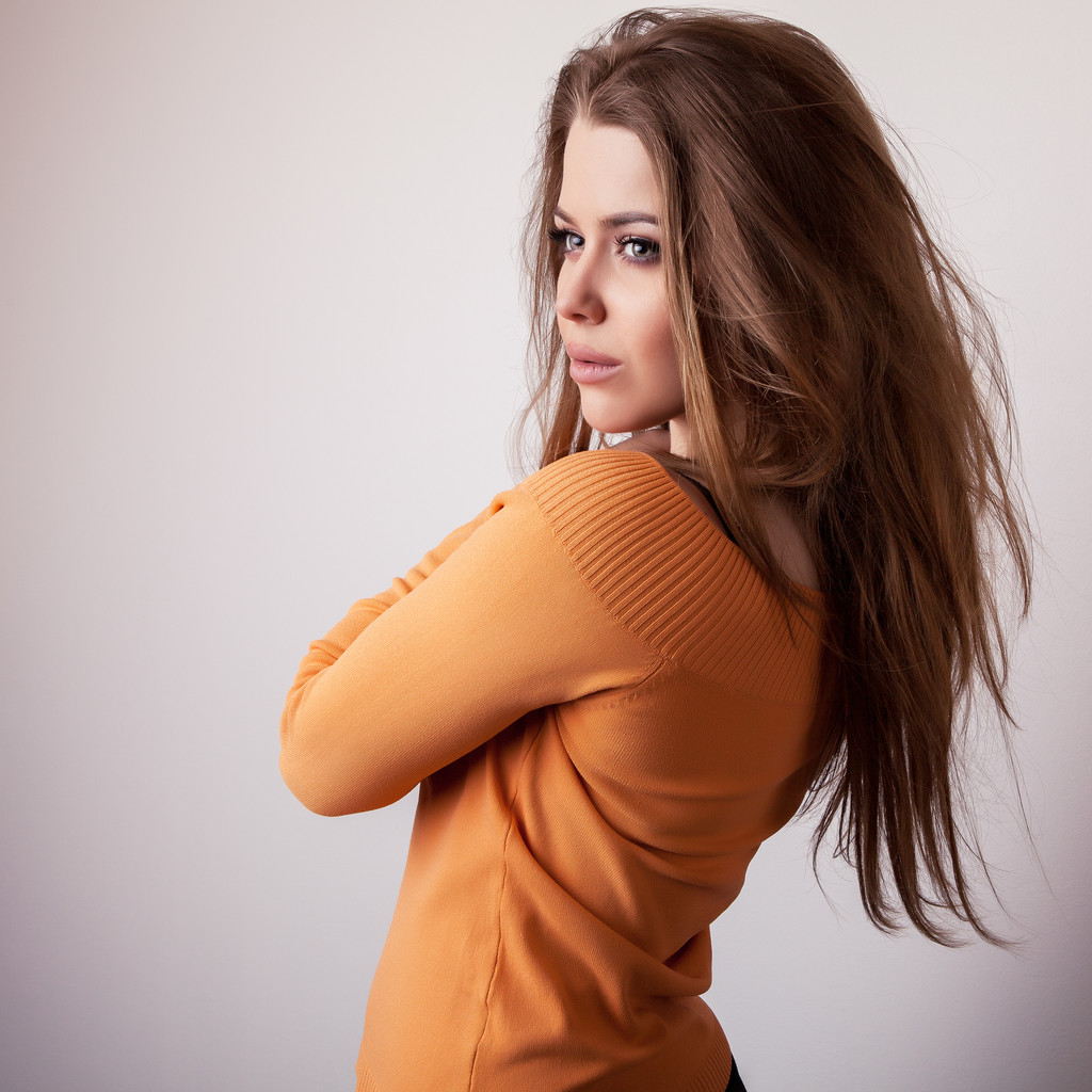 Jovem sensual & beleza modelo menina iin casual laranja suéter pose no estúdio
. - Foto, Imagem