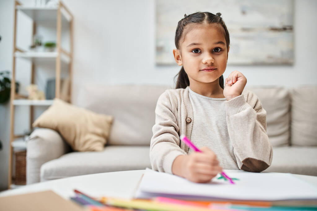 kis aranyos elemi lány rajz színes ceruza, papír a modern lakásban - Fotó, kép