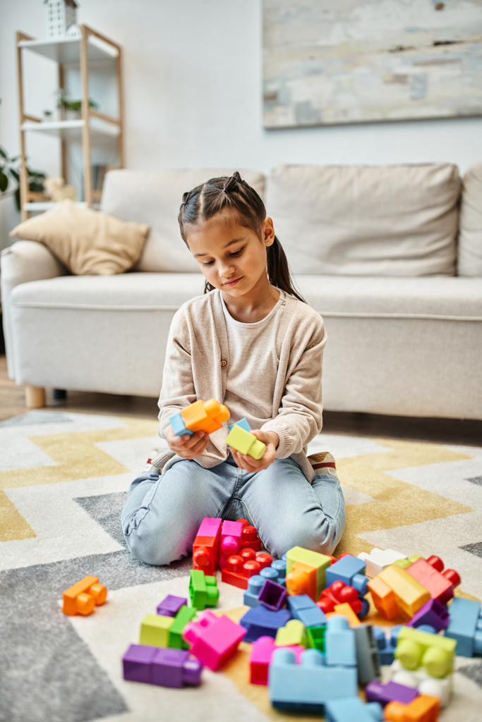 carina bambina che gioca con blocchi di giocattoli colorati sul tappeto in soggiorno, costruzione torre di gioco - Foto, immagini