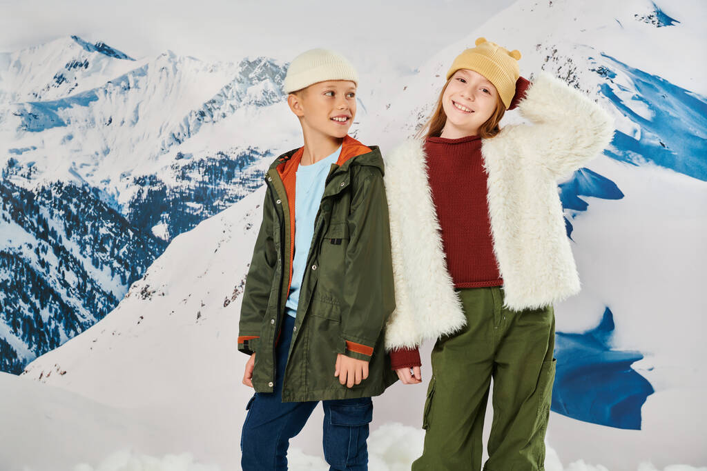 pieni poika katselee söpö tyttö, molemmat yllään talvi lämmin asuja ja hymyillen iloisesti, muoti - Valokuva, kuva