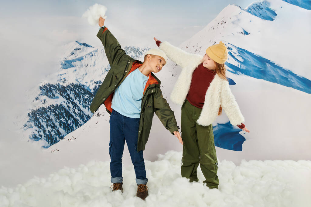 stylish friends in warm attire posing in motion, holding hands like a plane fly, fashion concept - Photo, Image
