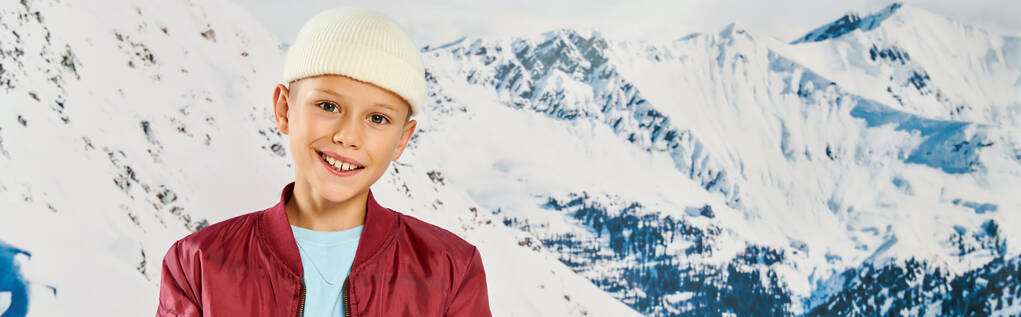 joyful little boy in stylish attire with beanie hat smiling at camera, fashion concept, banner - Photo, Image
