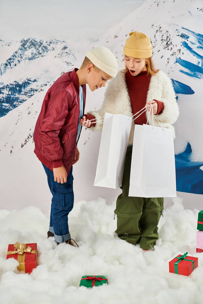 vertical shot of little friends looking happily and excitedly in present bag, fashion concept - Photo, Image