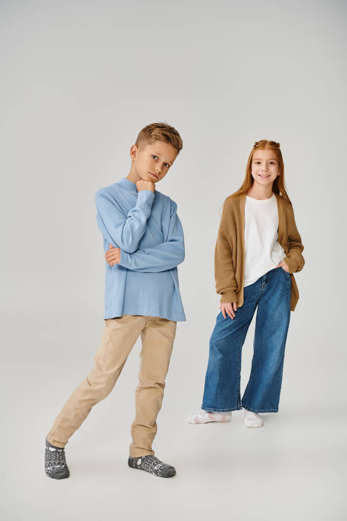 ブルースウェットシャツの深刻な19歳の男の子の近くに編まれたニットカーディガンのジョリー少女の垂直ショット - 写真・画像