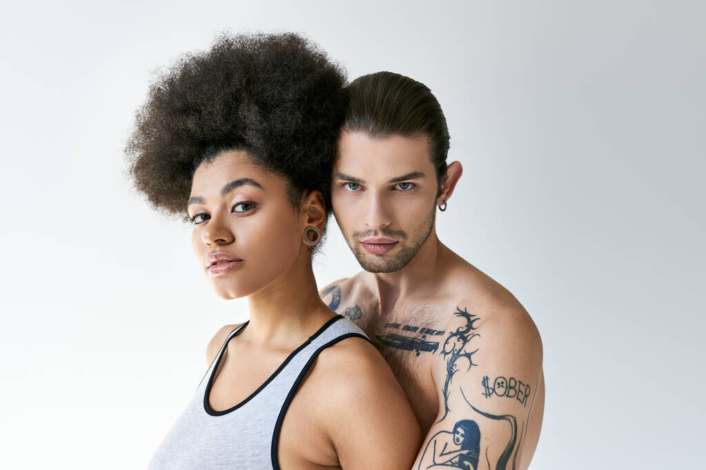 dobře vypadající tetovaný muž objímající svou africkou americkou přítelkyni zezadu, sexy pár - Fotografie, Obrázek