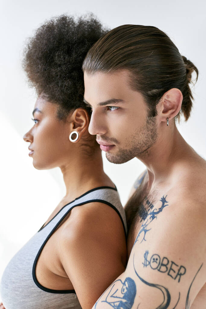 bell'uomo tatuato che abbraccia la sua bella ragazza africana americana da dietro, coppia sexy - Foto, immagini