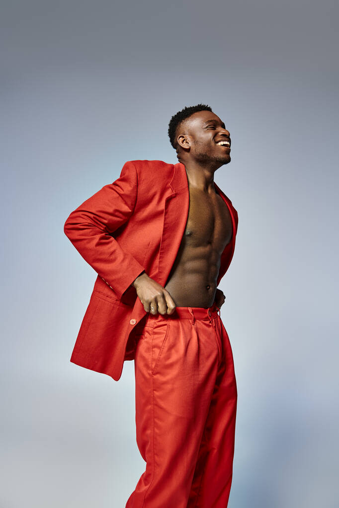 jovem modelo masculino afro-americano com vibrante estilo dapper posando em pano de fundo cinza, conceito de moda - Foto, Imagem
