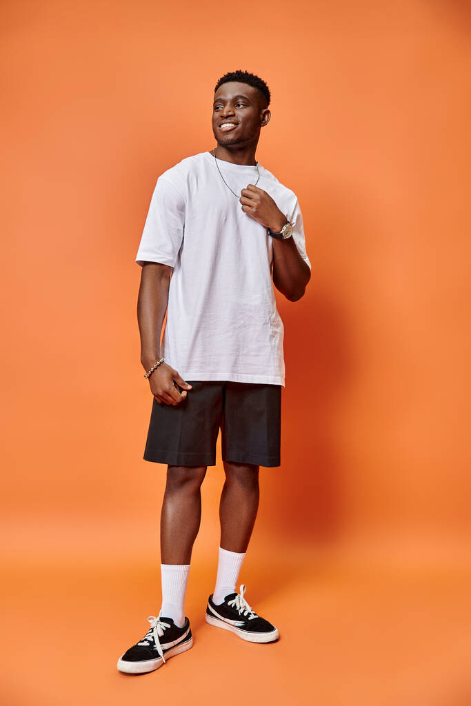 allegro giovane uomo africano americano in abito casual strada su sfondo arancione, concetto di moda - Foto, immagini