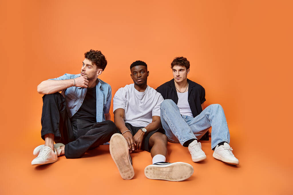 handsome multicultural stylish men in trendy urban outfits sitting on floor, fashion concept - Photo, Image